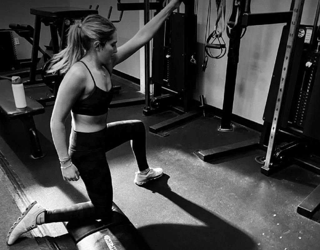 Kaili doing kneeling cable exercise with Mark McIntosh - black and white photo